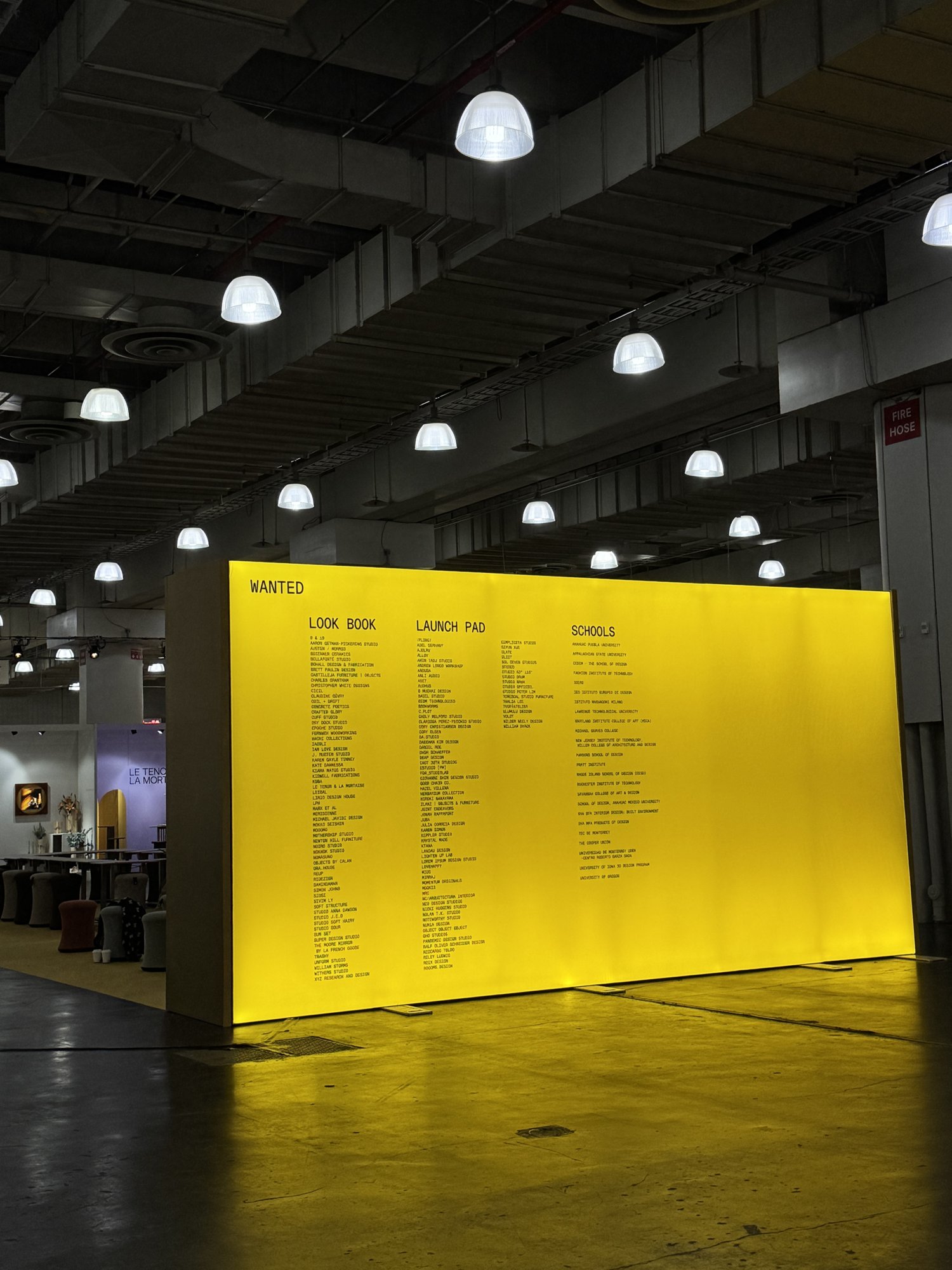 Muro amarillo iluminado con la palabra WANTED, dentro de la feria ICFF